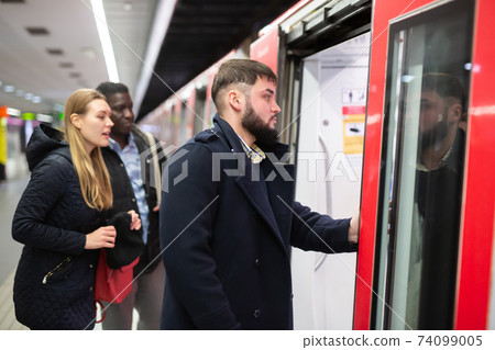 Guy getting on subway train Guy getting on subway train 74099005