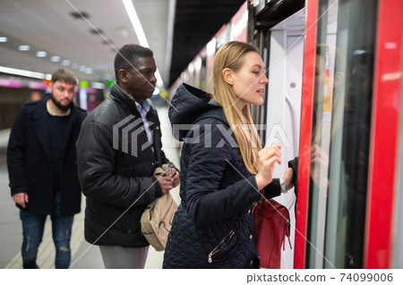 Woman getting on subway car Woman getting on subway car 74099006