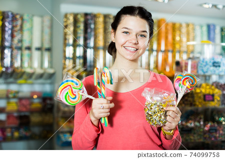 girl buying candies at shop 74099758