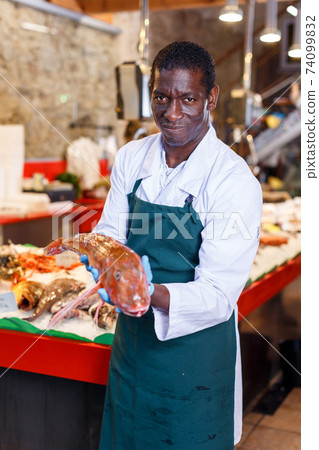 Salesman offering fresh fish 74099832