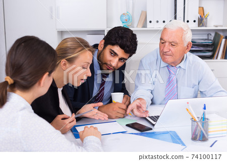 Managers are writing financial reports and discussing with mature boss Managers are writing financial reports and discussing with mature boss 74100117
