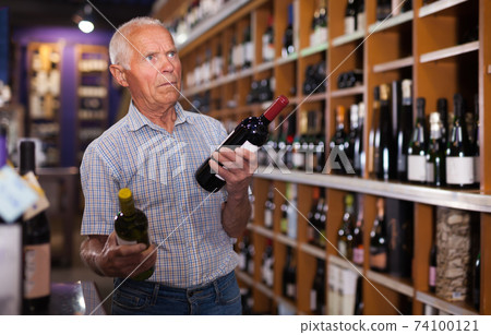 Elderly man visiting winehouse in search of wine 74100121