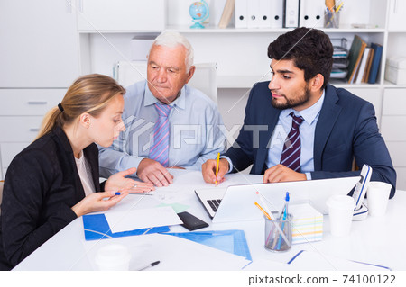 Managers are writing financial reports and discussing with mature boss Managers are writing financial reports and discussing with mature boss 74100122