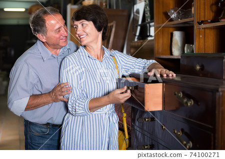 woman with her husband are buying antique curbstone in store 74100271