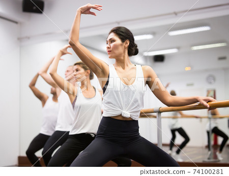 Woman practicing ballet elements in class 74100281