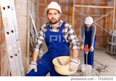 Portrait of builder in process of finishing work in cottage 74100282