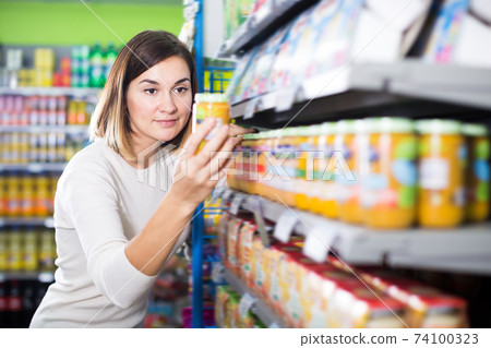 Glad female shopper searching for baby food 74100323