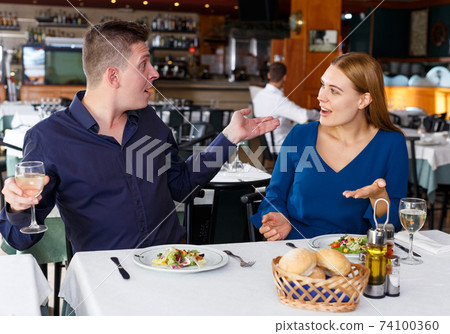 Upset man and woman quarreling in restaurant Upset man and woman quarreling in restaurant 74100360
