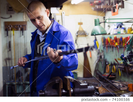 Lubricating and cleaning the barrel of rifle in gun workshop Lubricating and cleaning the barrel of rifle in gun workshop 74100386
