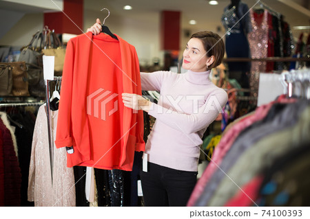 Woman choosing knitwear cardigan Woman choosing knitwear cardigan 74100393