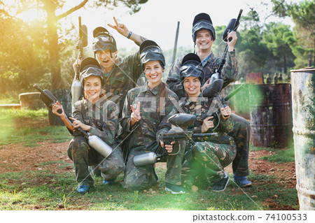 Portrait of paintball players wearing uniform and holding guns r Portrait of paintball players wearing uniform and holding guns r 74100533