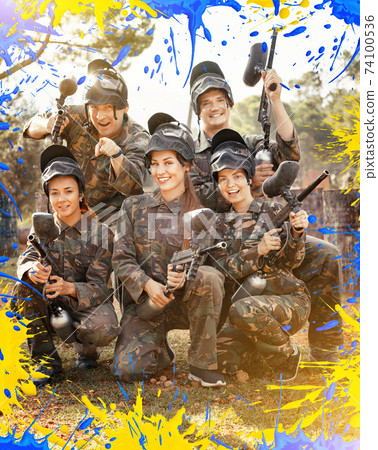 Portrait of paintball players wearing uniform and holding guns r Portrait of paintball players wearing uniform and holding guns r 74100536