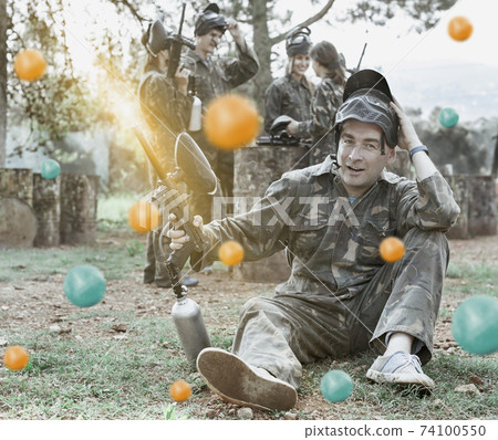 Paintball player in camouflage with gun Paintball player in camouflage with gun 74100550