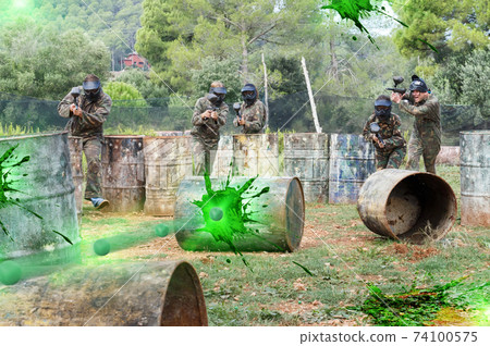 Group of people playing paintball Group of people playing paintball 74100575