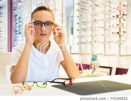 Male client trying on new spectacles in medical shop Male client trying on new spectacles in medical shop 74100682