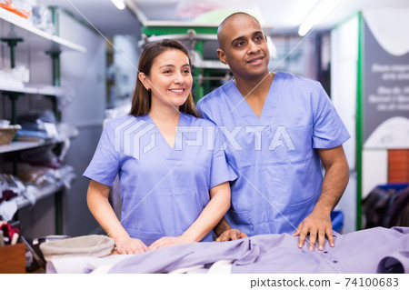 Portrait of two workers of dry-cleaning facility Portrait of two workers of dry-cleaning facility 74100683