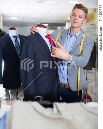 Adult male in shirt measuring jacket Adult male in shirt measuring jacket 74100783