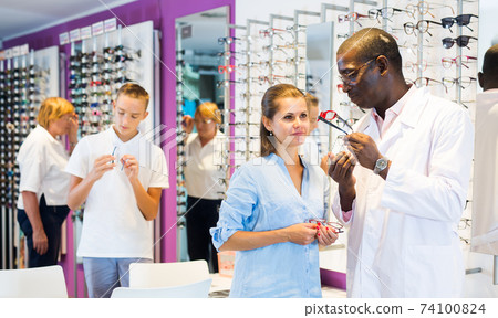 African-American ophthalmologist consulting young woman African-American ophthalmologist consulting young woman 74100824