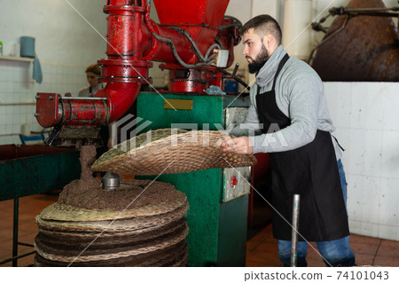 Worker forming pile from fiber mats with olive paste Worker forming pile from fiber mats with olive paste 74101043