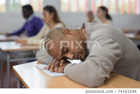 Tired bored adult man sleeping during lesson Tired bored adult man sleeping during lesson 74101046