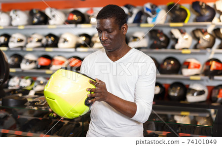 Nice Afro man choosing biker accessories Nice Afro man choosing biker accessories 74101049
