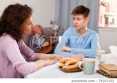 Boy talking to mother on background with indifferent father 74101102