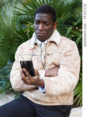 Unhappy man talking on phone Unhappy man talking on phone 74101128