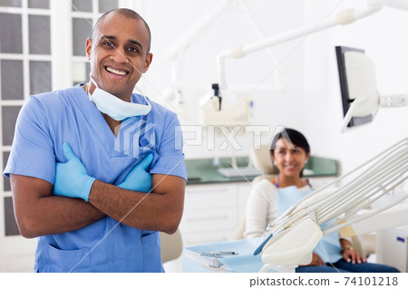 Successful professional dentist standing in modern dental office 74101218