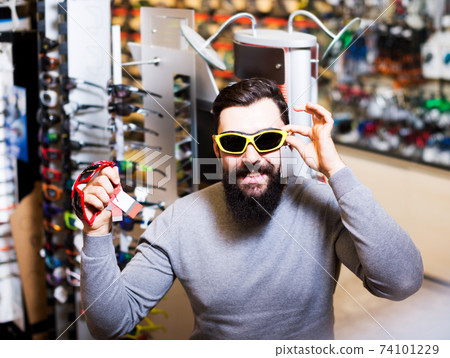 Guy deciding on new sunglasses Guy deciding on new sunglasses 74101229