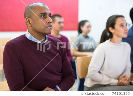 Group of students attentively listening to lecture in classroom 74101393