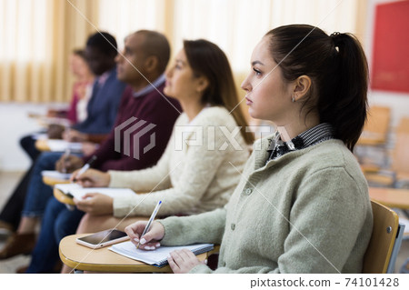 Side view of student group working on lecture in classroom 74101428