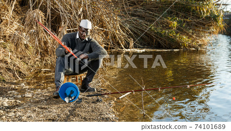 Man pulling fish with rods on river Man pulling fish with rods on river 74101689
