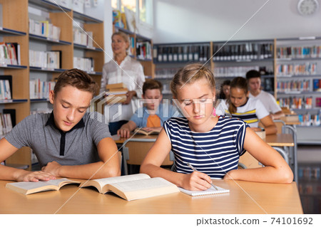 Students reading books in library Students reading books in library 74101692