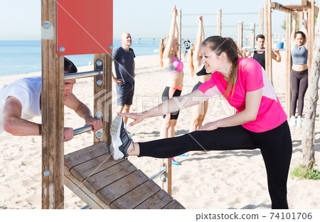 people doing workout on beach in sunny morning people doing workout on beach in sunny morning 74101706