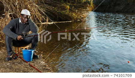 Bored man fishing with rods 74101709