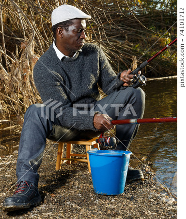 Man fishing with rods on river 74101712
