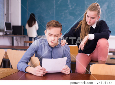 Teen girl comforting sad coursemate Teen girl comforting sad coursemate 74101758