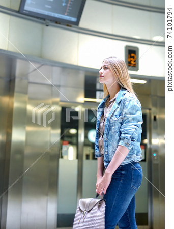 Girl with long hair looks train schedule in the subway Girl with long hair looks train schedule in the subway 74101794
