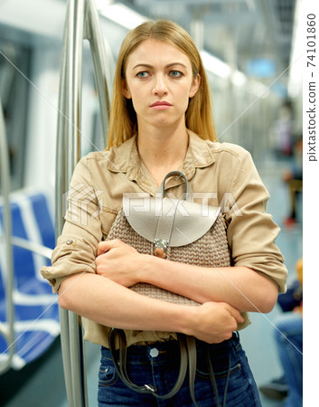 Blonde fears for her handbag in the subway car Blonde fears for her handbag in the subway car 74101860