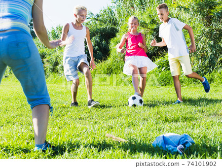 Group of laughing children playing football 74101902
