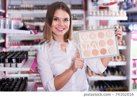 Salesgirl proposing powder in shop 74102016