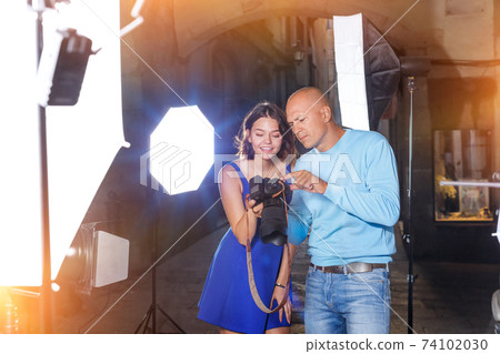 Photographer showing photos on camera to model girl Photographer showing photos on camera to model girl 74102030