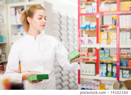 Young friendly female pharmacist suggesting useful tablets in pharmacy Young friendly female pharmacist suggesting useful tablets in pharmacy 74102184