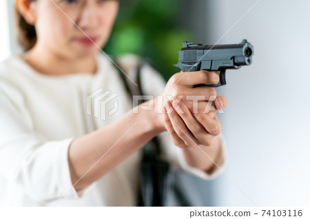 Female plainclothes policeman holding a gun 74103116