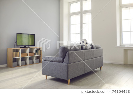 Modern living-room with a comfortable soft couch and a TV set with a soccer match on Modern living-room with a comfortable soft couch and a TV set with a soccer match on 74104438