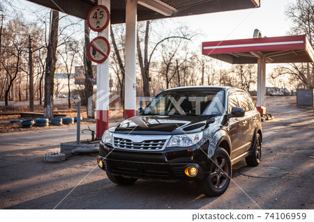 Black crossover at abandoned gas station Black crossover at abandoned gas station 74106959