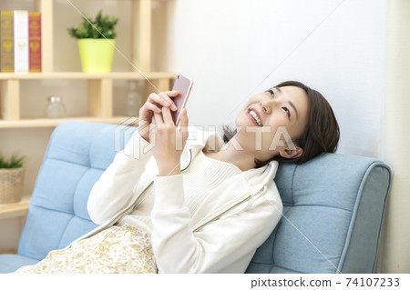 Woman using a smartphone 74107233