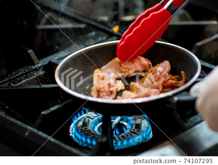 fresh fried bacon in a pan, Chef cooking in the kitchen fresh fried bacon in a pan, Chef cooking in the kitchen 74107295