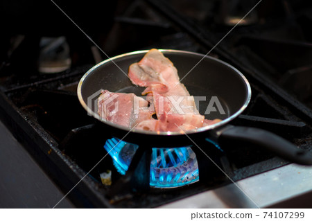 fresh fried bacon in a pan, Chef cooking in the kitchen fresh fried bacon in a pan, Chef cooking in the kitchen 74107299