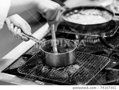 Chef cooking in a kitchen, chef at work, Black and White. Chef cooking in a kitchen, chef at work, Black and White. 74107301